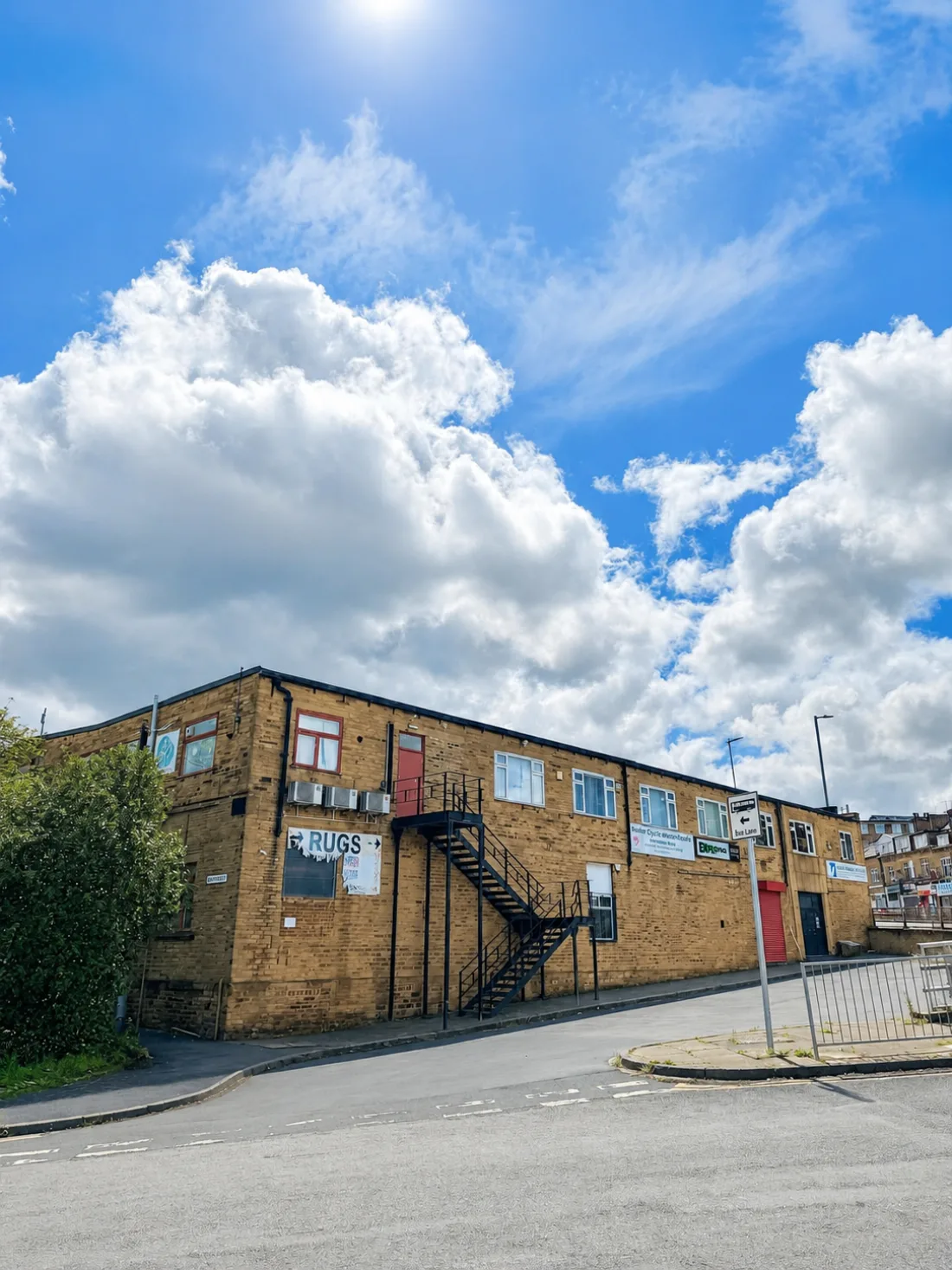 Wide corner view of St Stephens Mill, Bradford — the two-storey Yorkshire-stone building housing Space Buddy Self Storage, photographed from the street corner showing the full frontage and external staircase